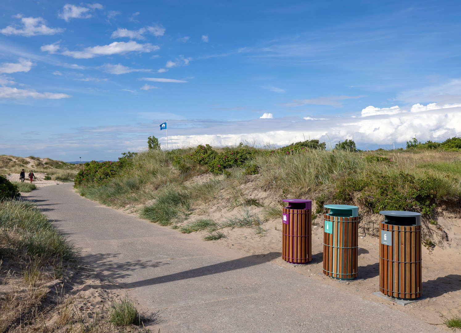 Affaldssortering på strand med blåt flag